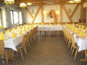 a large room with tables and chairs with yellow napkins at Landgasthaus Löwen mit Gästehaus in Holzhausen