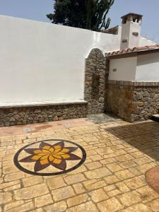 a stone patio with a flower design on the ground at Casa Marisol in San Giovanni Suèrgiu