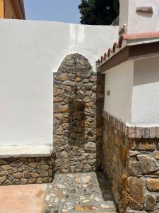 a stone wall with an arch in the side of a building at Casa Marisol in San Giovanni Suèrgiu +1 photo
