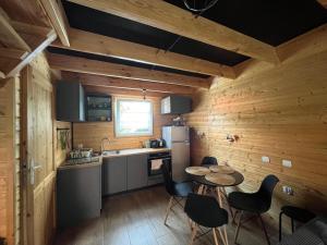 a kitchen with wooden walls and a table and chairs at Opawski Zakątek 43 in Pokrzywna
