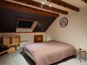MoyeにあるGîte Le Parmandのベッドルーム1室(ベッド1台、壁掛け時計付)