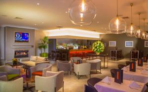 um restaurante com mesas e cadeiras e um bar em Sudima Hotel Christchurch Airport em Christchurch