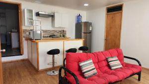 un salon avec un canapé rouge et une cuisine dans l'établissement Arriendo de Verano 4 dormitorios, à Valparaíso