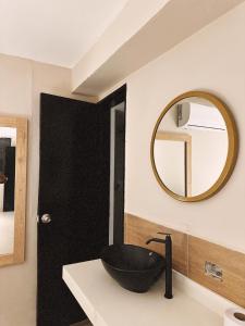 Un baño con un lavabo negro y un espejo. en Hotel Coral Boutique, en Medellín