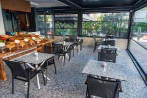 a restaurant with tables and chairs and windows at Lucky Monkey Midi Hotel in Antalya