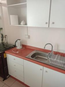 a kitchen counter with a sink and a microwave at Departamento frente a playa Bellavista in Tomé