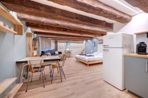 a kitchen and living room with a refrigerator and a bed at La Cabane Bellecour in Lyon