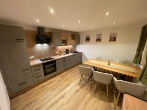 a large kitchen with a wooden table and chairs at Apartment Gschwandtl in Taxenbach