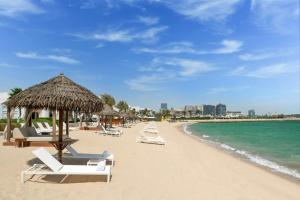 ドーハにあるSharq Village & Spa, a Ritz-Carlton Hotelの海の景色を望むビーチ(椅子、パラソル付)