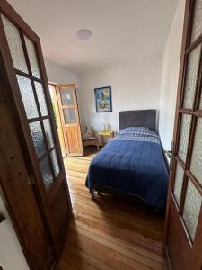 une chambre avec un lit recouvert d'une couette bleue dans l'établissement Helen House, à Bogotá