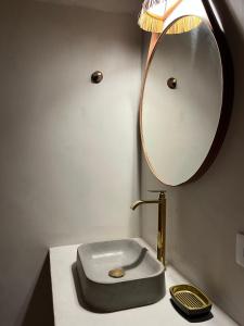 um banheiro com uma pia e um espelho em Pousada Amora Caraiva em Caraíva