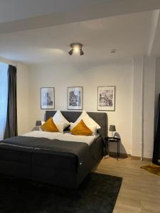 a bedroom with a large bed with yellow pillows at City Apartments Trier Suite 3 in Trier