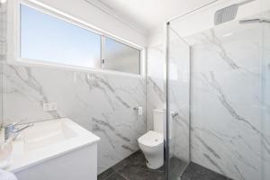 a bathroom with a toilet and a sink and a shower at Gladstone CBD Motel in Gladstone +12 photos