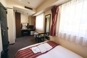 Una habitación de hotel con una cama y una ventana. en Hotel Astir Nagoya Sakae, en Aoichō