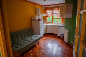a living room with a couch and a kitchen at Hotel Cima Argentum in Potosí