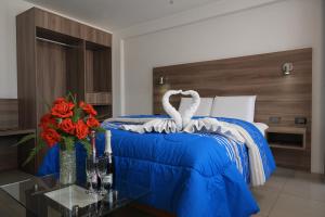 a bedroom with a bed with a blue blanket and flowers at PRIVATE ROOMS - DOWNTOWN AREQUIPA - GM Collection in Arequipa