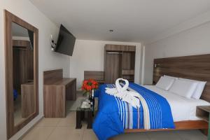 a bedroom with a bed with a blue and white blanket at PRIVATE ROOMS - DOWNTOWN AREQUIPA - GM Collection in Arequipa