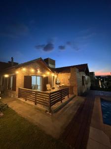 a house with a deck and a pool at night at Margaritas House in La Falda