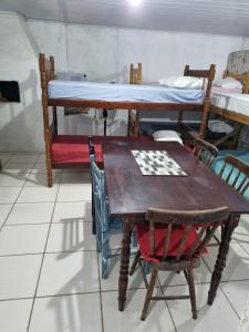 a table and chairs and a bed in a room at Oca do Ric in Imbituba