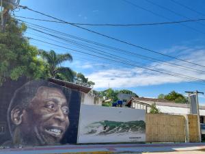 a large painting of a man on the side of a building at Oca do Ric in Imbituba