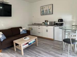 a living room with a couch and a table at Westshore Garden Escape in Victoria +13 photos