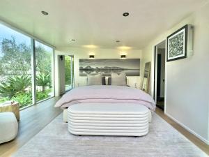 a bedroom with a large bed with a large window at The Glass House Montecito in Santa Barbara