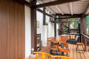 a room with a wooden table and chairs on a balcony at Hangzhou Qinghuan Homestay in Hangzhou