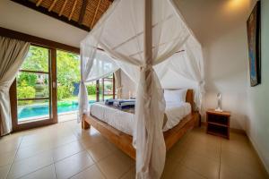 Ένα ή περισσότερα κρεβάτια σε δωμάτιο στο Bali Sunyi Villas +288 φωτογραφίες