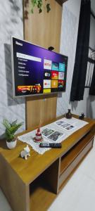 a desk with a tv on top of it at Pé na Areia Gonzaguinha Perto de Tudo in São Vicente