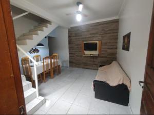un salon avec un escalier et une salle à manger dans l'établissement Casa na praia férias, à Vila Balneária