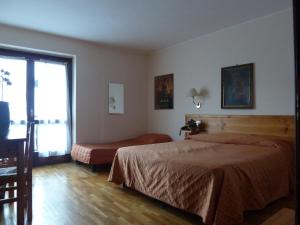 una camera d'albergo con letto e finestra di Hotel Le Verger a Châtillon