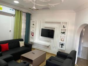 a living room with a couch and a tv at Saceaas homes in Accra