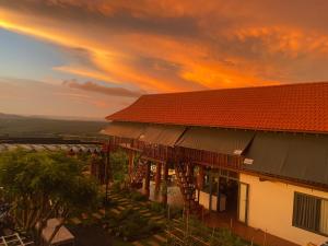 a building with a sunset in the background at Homestay Lưng Đồi in Buôn Dhă Prŏng