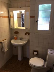 a bathroom with a toilet and a sink and a window at Lazlo in Sierra de los Padres