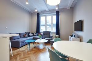 a living room with a couch and a table and chairs at PlayRoom II Apartment in Krakow