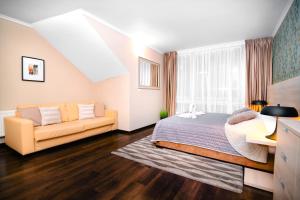 a bedroom with a bed and a couch at Spirit Harrachov Superior Wellness Apartment - FREE Wellness, Wifi, Parking in Harrachov