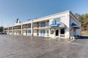 un gran edificio blanco con aparcamiento en Motel 6-Kingston, TN, en Kingston