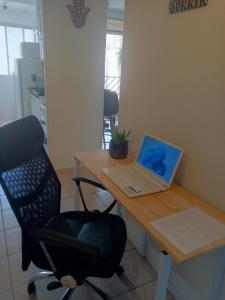 a desk with a laptop and a chair on it at Espaço Van Gogh in Campinas