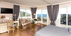 リャフランにあるHotel BlauMar Llafrancのベッド、デスク、デスクが備わるホテルルームです。
