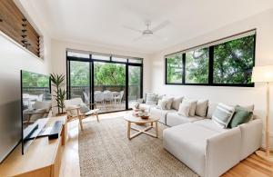 a living room with white furniture and large windows at The Sunshine Beach Luxe Coastal Retreat in Sunshine Beach