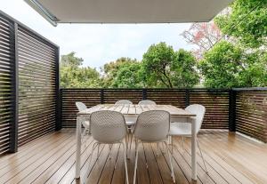 a dining room with a table and chairs on a deck at The Sunshine Beach Luxe Coastal Retreat in Sunshine Beach