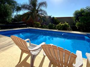 two chairs sitting next to a swimming pool at La Cantata in Merlo +21 photos