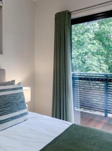 a bedroom with a bed and a large window at The Sunshine Beach Luxe Coastal Retreat in Sunshine Beach
