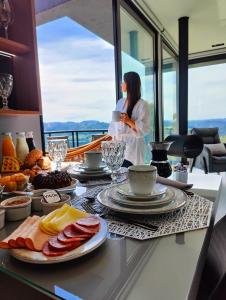 a woman standing in front of a table with food at Sombra na Montanha in Nova Petrópolis