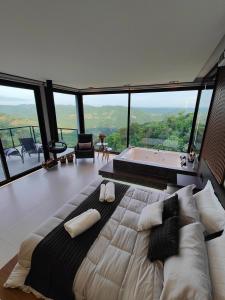 a bedroom with a large bed and a bath tub at Sombra na Montanha in Nova Petrópolis