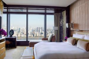 a hotel room with a large bed and a large window at The Ritz-Carlton Shanghai, Pudong in Shanghai