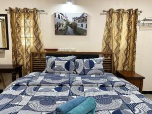 a bedroom with a bed with blue and white pillows at 3BR Villa near Boat Avenue Laguna beach in Bang Tao Beach