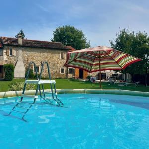 a swimming pool with two chairs and an umbrella at Villa storica 3Lasagne, tra Verona e Venezia in Lonigo