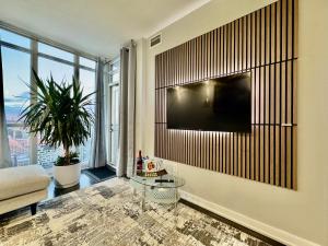 a living room with a tv on a wall at TVHR - Luxury Condos in Heart of Downtown with Breakfast in Toronto