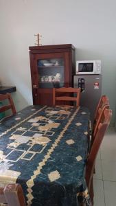 a kitchen with a table and chairs with a cross on it at KaLong Bay Homestay Villa Seroja in Kampong Telok Kalong